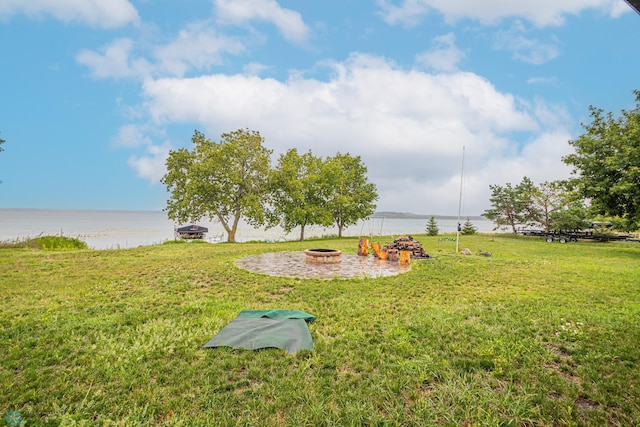 view of yard with a water view and an outdoor fire pit