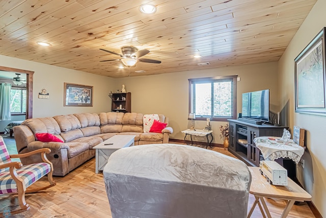 living room with light hardwood / wood-style flooring, wood ceiling, a wood stove, and ceiling fan