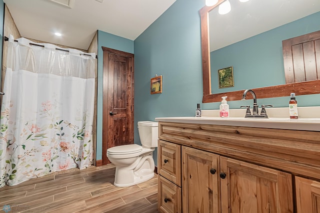 bathroom featuring curtained shower, hardwood / wood-style flooring, vanity, and toilet