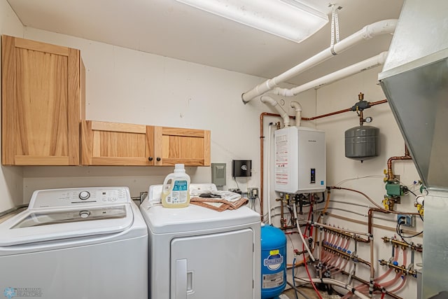 washroom with water heater, washer and dryer, and cabinets