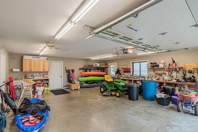 garage featuring ceiling fan, a garage door opener, and a workshop area