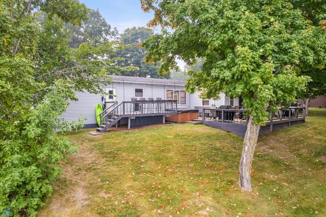 rear view of house featuring a lawn and a deck