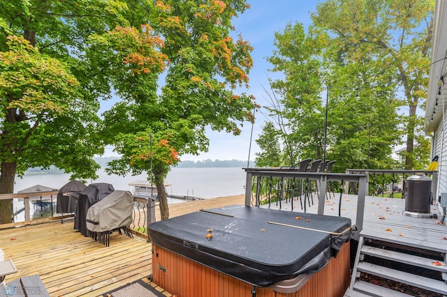 deck with a hot tub and a water view