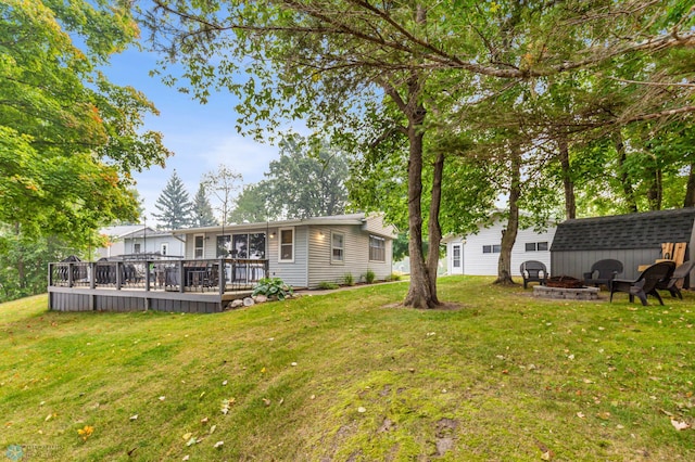 view of yard featuring an outdoor fire pit and a deck