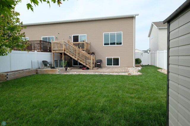 back of house featuring a wooden deck and a lawn