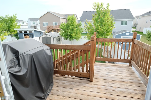 deck with a storage shed and a grill