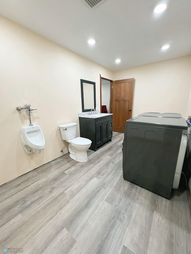 bathroom with washer / dryer, vanity, toilet, and hardwood / wood-style flooring