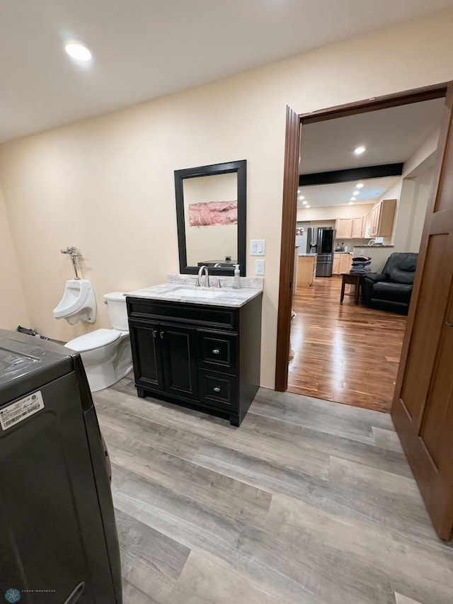 bathroom with vanity, toilet, and hardwood / wood-style floors