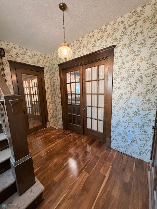 entryway with french doors, dark hardwood / wood-style flooring, and a textured ceiling