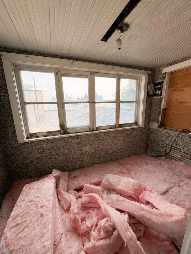 interior space featuring multiple windows, ceiling fan, and wood ceiling