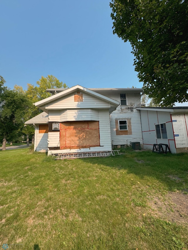 back of house featuring central AC and a yard