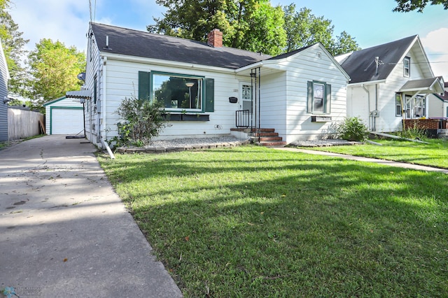 view of front of property featuring a garage, a front lawn, and an outbuilding