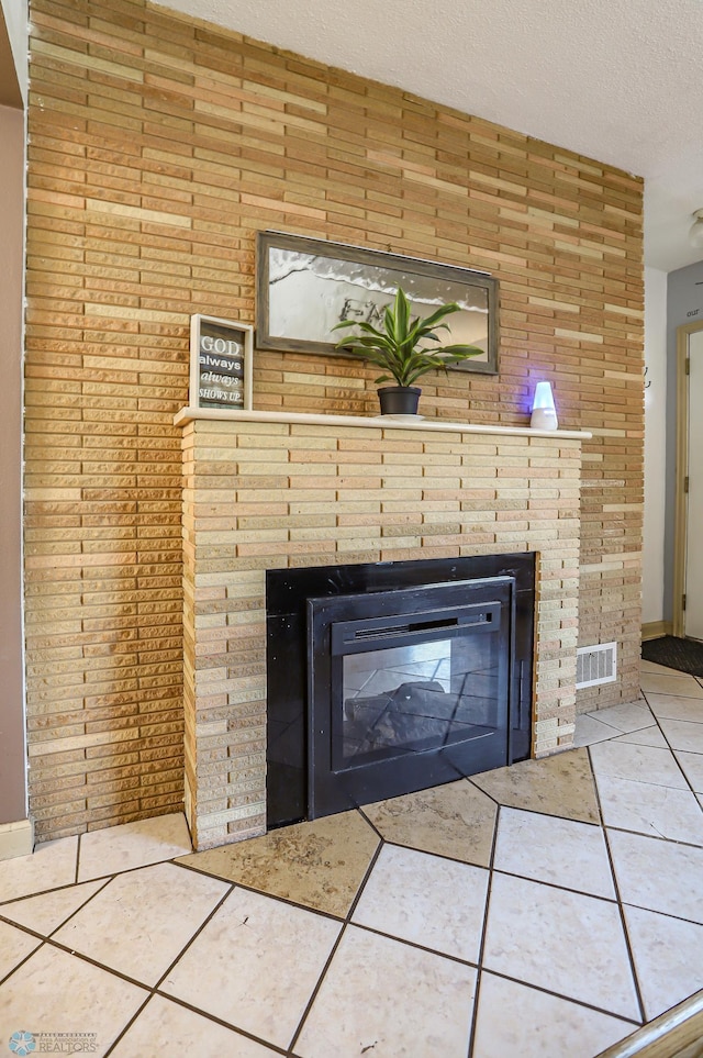 details with a textured ceiling, a large fireplace, and tile patterned floors