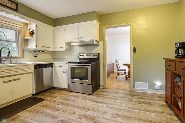 kitchen featuring white cabinets, appliances with stainless steel finishes, light hardwood / wood-style floors, sink, and exhaust hood