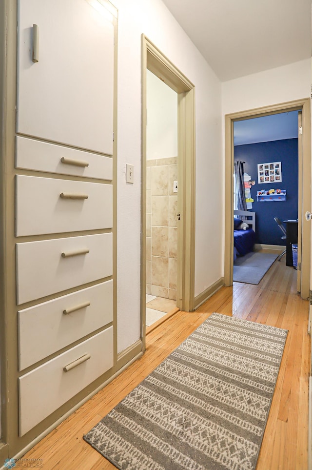 corridor with light hardwood / wood-style floors