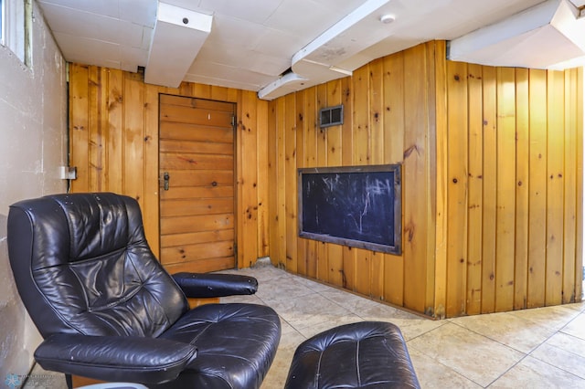 living area with wooden walls and light tile patterned flooring