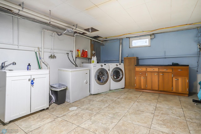 laundry room with washer and dryer, cabinets, sink, and light tile patterned flooring