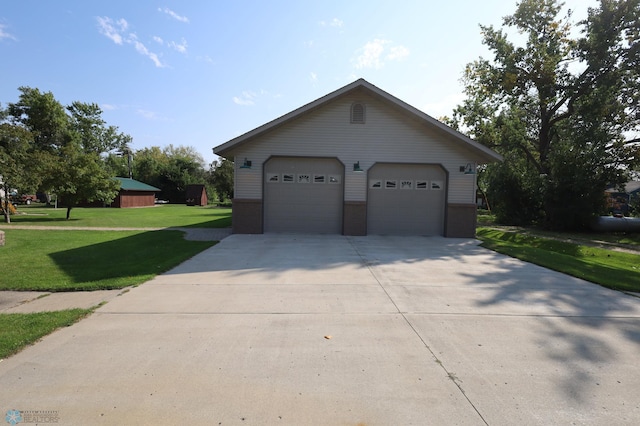 exterior space with a garage, a front lawn, and an outbuilding