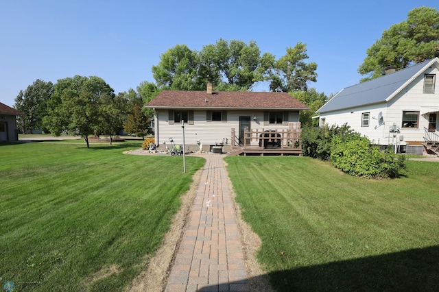 back of house featuring a lawn and a wooden deck