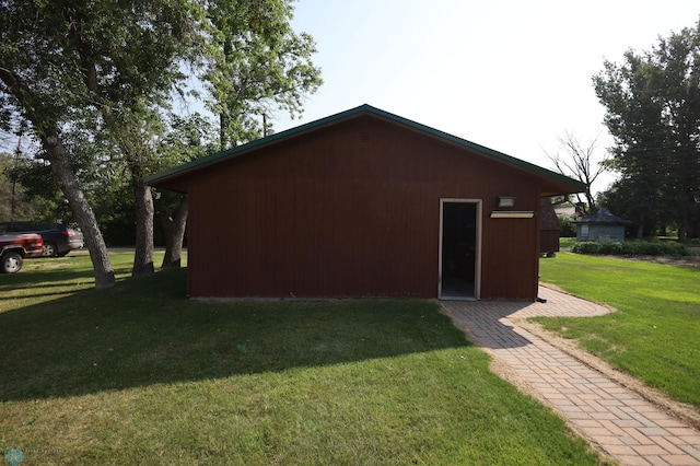 view of side of home featuring a yard and an outbuilding