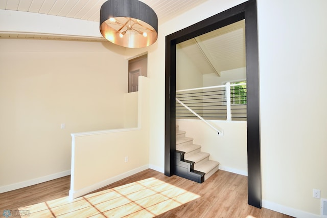 staircase with vaulted ceiling with beams, wood ceiling, and hardwood / wood-style flooring