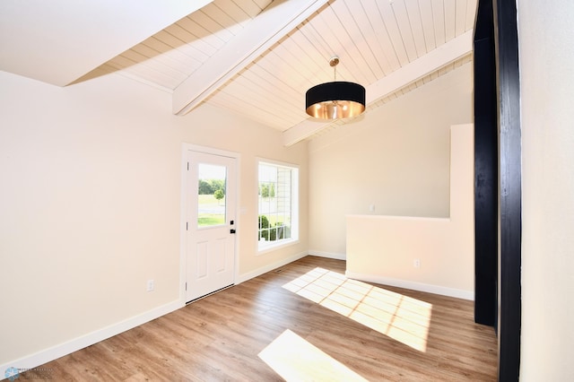 foyer entrance with wooden ceiling, vaulted ceiling with beams, and hardwood / wood-style floors