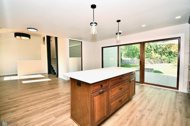 kitchen featuring light wood-type flooring, a center island, and hanging light fixtures