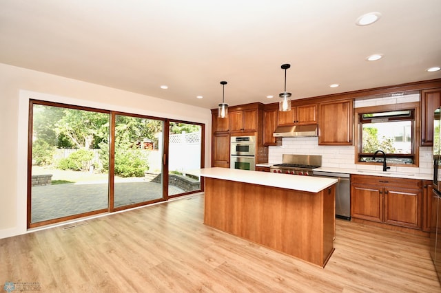 kitchen with light hardwood / wood-style floors, sink, and decorative light fixtures