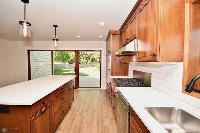 kitchen featuring sink, decorative light fixtures, backsplash, light hardwood / wood-style flooring, and dishwasher