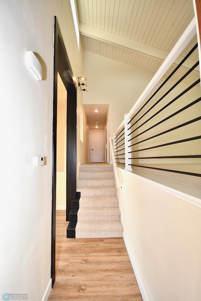 corridor featuring wooden ceiling, vaulted ceiling with beams, and light hardwood / wood-style floors