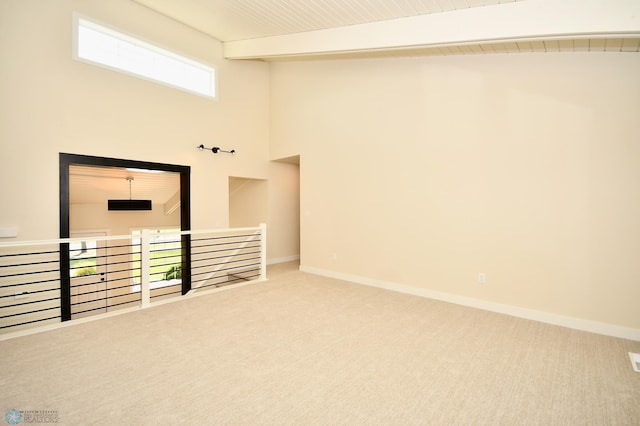 carpeted spare room with high vaulted ceiling and beam ceiling