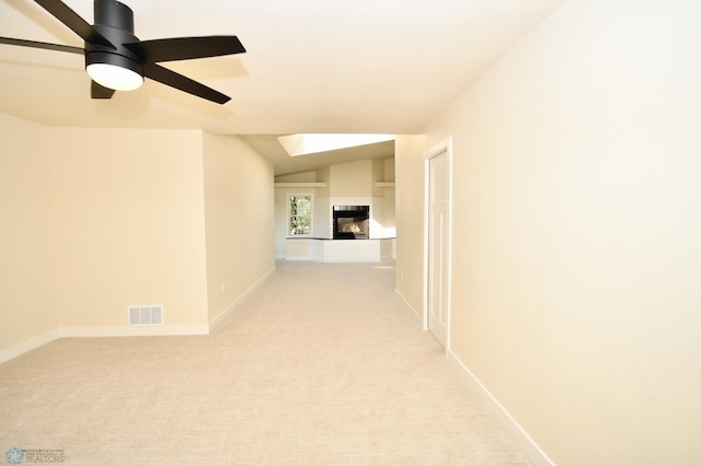 hallway with light colored carpet and vaulted ceiling