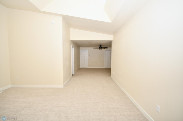 hall with vaulted ceiling and light carpet