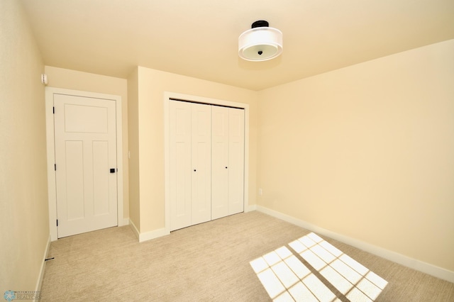 unfurnished bedroom featuring light carpet and a closet