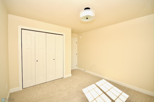 unfurnished bedroom with light carpet and a closet