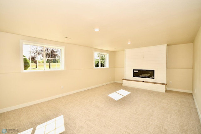 unfurnished living room featuring a fireplace and light carpet