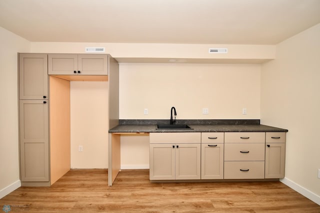 bar featuring light wood-type flooring and sink