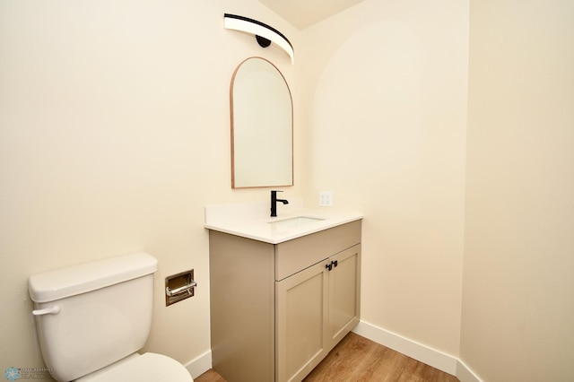 bathroom with vanity, toilet, and hardwood / wood-style flooring