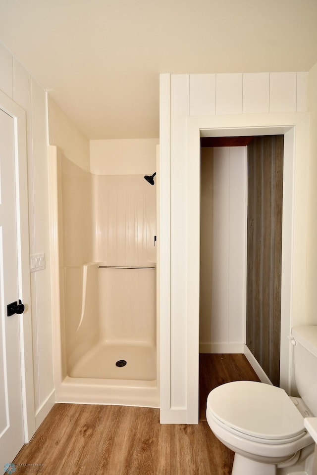 bathroom featuring walk in shower, toilet, and hardwood / wood-style floors