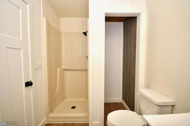 bathroom featuring walk in shower, toilet, and wood-type flooring