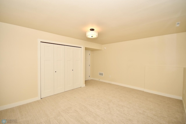 unfurnished bedroom with a closet and light colored carpet