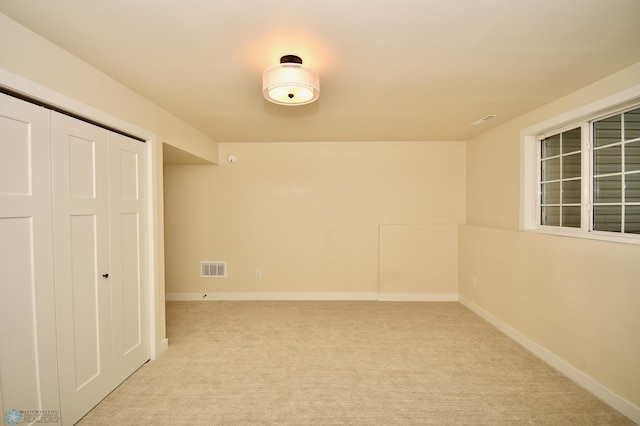 unfurnished bedroom featuring light carpet and a closet