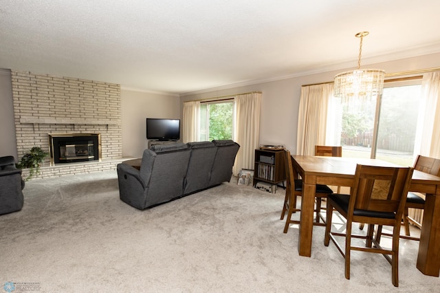 dining space featuring a fireplace, ornamental molding, an inviting chandelier, and light colored carpet