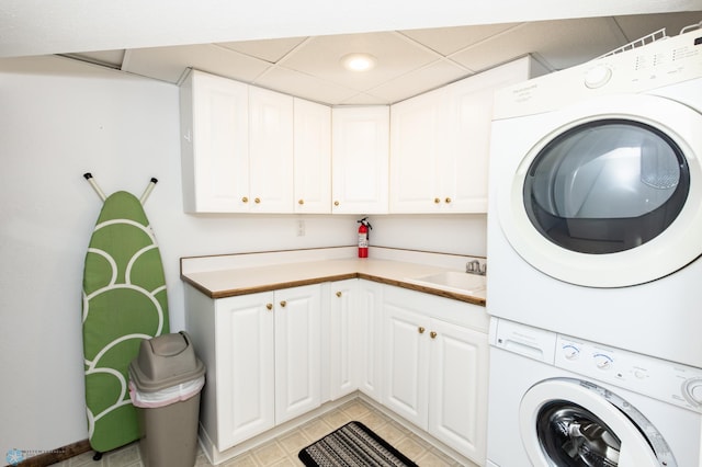 laundry area featuring sink, cabinets, and stacked washer / drying machine