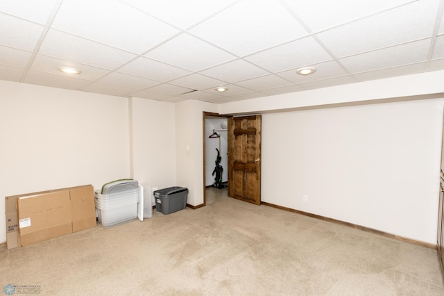 unfurnished room featuring a paneled ceiling and light carpet