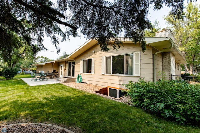 view of side of home featuring a patio area and a lawn