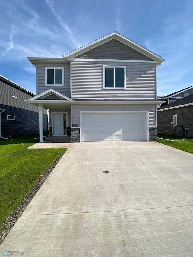 view of front property featuring a front lawn and a garage