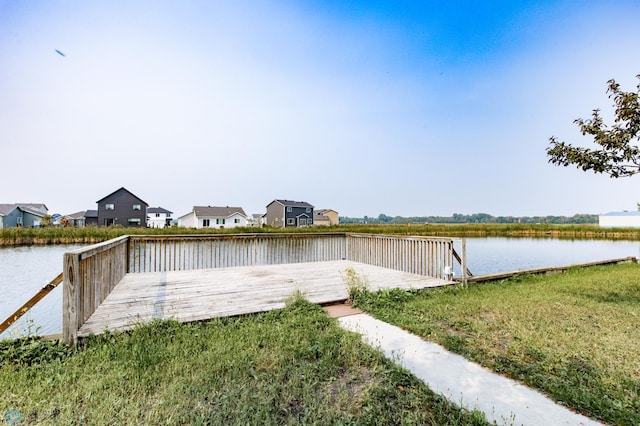 view of dock featuring a yard and a deck with water view