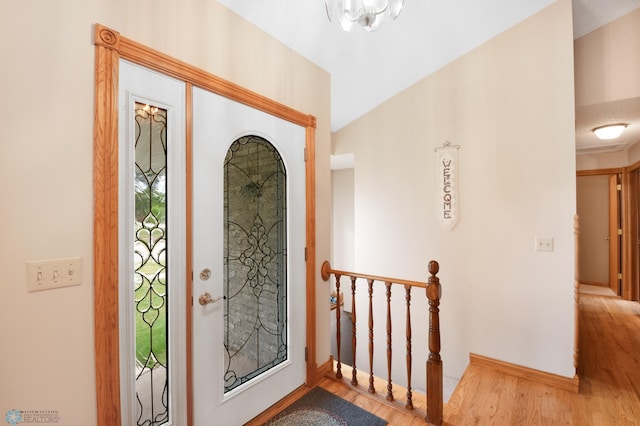 foyer entrance featuring light wood-type flooring and a chandelier