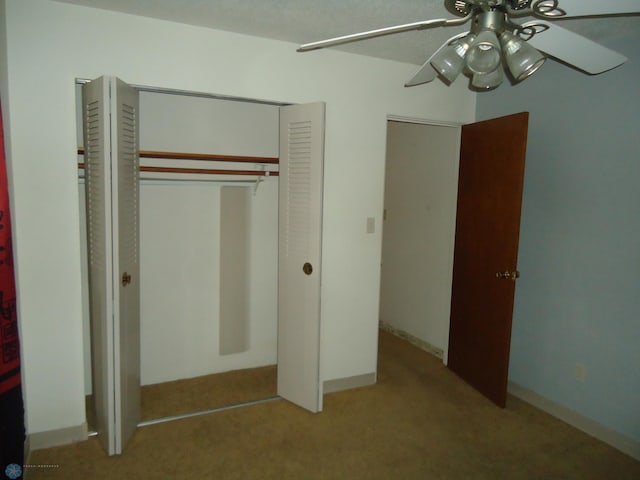 interior space featuring ceiling fan, light colored carpet, and a closet